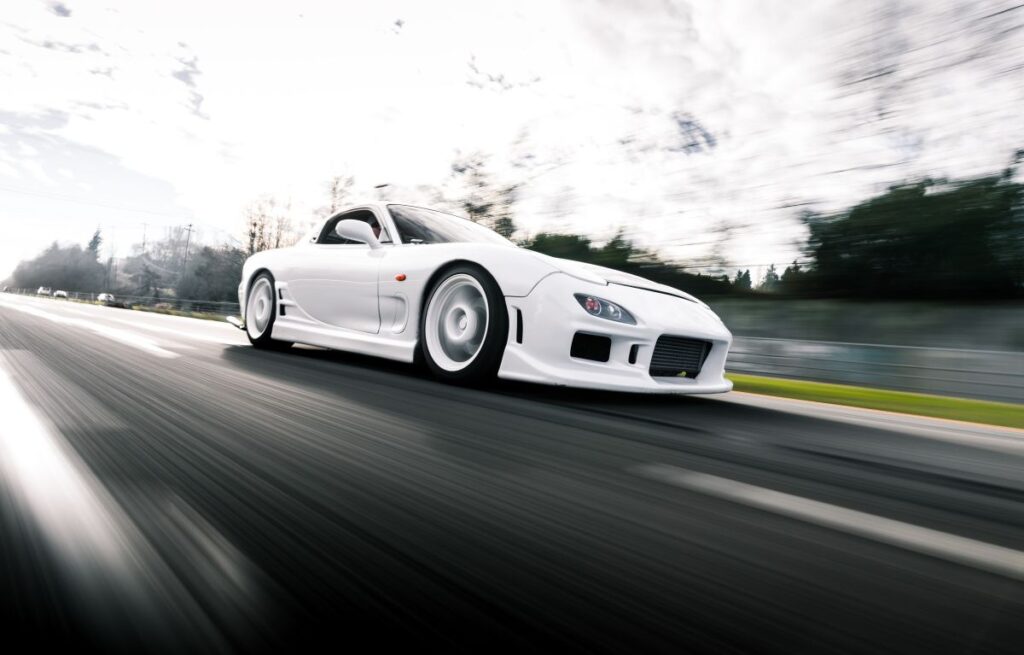 White RX-7 racing down the road