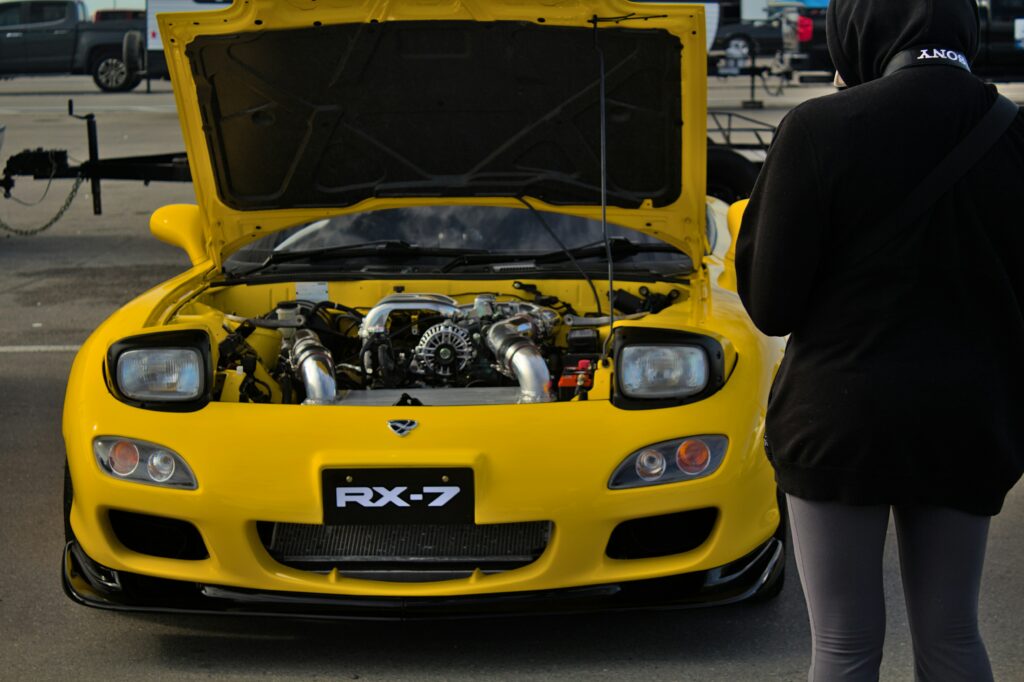 A shot of a yellow RX-7, with its bonnet open