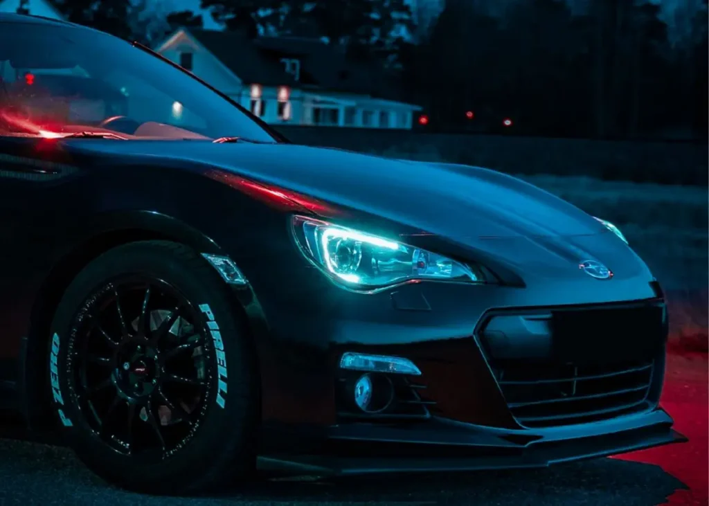 Subaru BRZ with headlights on in the dark